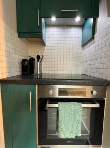 uma cozinha com armários verdes e um forno com uma toalha em Temple Bar Apart em Dublin
