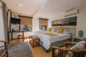 1 dormitorio con 1 cama grande y escritorio en Beetleloop Guest House en Nelspruit
