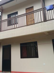 ein Gebäude mit einem Balkon mit einer Tür und Fenstern in der Unterkunft Eve's Place Transient Apartment in Tanay