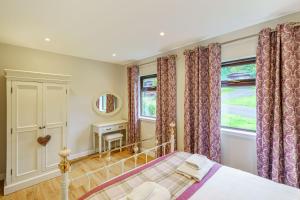 a bedroom with a bed and a window at Bluebell Lodge 10 with Hot Tub in Newton Stewart