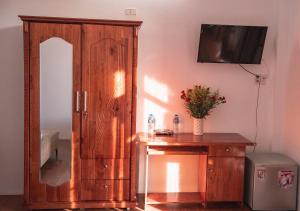 Habitación con armario de madera y mesa con espejo. en Vang Anh Homestay Hoi An en Hoi An