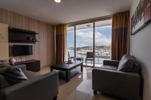 a living room with two couches and a large window at Valletta view Apartments by ST Hotels in Il- Gżira