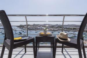 a table and chairs on a balcony with a view of a harbor at Valletta view Apartments by ST Hotels in Il- Gżira