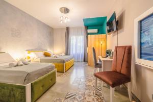 una camera d'albergo con due letti e una sedia di BeB Omare Agrigento a Agrigento