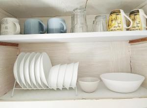 a shelf with plates and bowls in a kitchen at 生活超便利的小公寓 in Athens