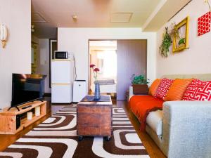 Una sala de estar con un sofá y un televisor en Cosy apartment K6/Direct to airport,CentralSapporo, en Toyohira