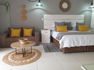- une chambre avec un lit, une table et un canapé dans l'établissement Damicha Boutique Lodge, à Ezulwini