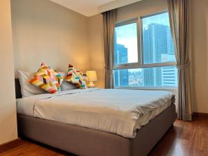 a bedroom with a bed with a large window at Belle Rama9 精品公寓 in Bangkok