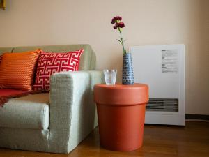 una flor en un jarrón en una mesa junto a un sofá en Cosy apartment K6/Direct to airport,CentralSapporo, en Toyohira