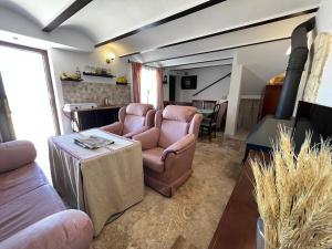 sala de estar con 2 sillas, sofá y mesa en Cortijo Domínguez - Rural Experience, en Lucena