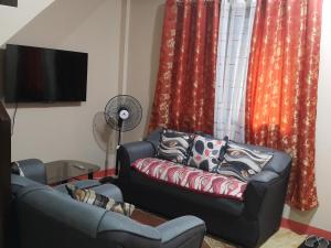 ein Wohnzimmer mit einem Sofa und roten Vorhängen in der Unterkunft Eve's Place Transient Apartment in Tanay