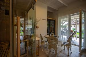 a dining room with chairs and a table and glass doors at Boutique Villa Gyula in Gyula
