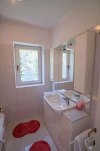 a white bathroom with a sink and a mirror at Apartment in Veli Losinj 34691 in Veli Lošinj