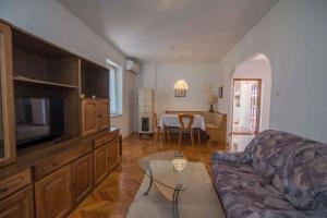 a living room with a couch and a table at Apartment in Veli Losinj 34691 in Veli Lošinj