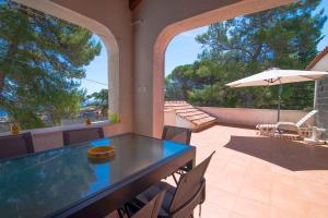 a patio with a table and chairs and an umbrella at Apartment in Veli Losinj 34691 in Veli Lošinj