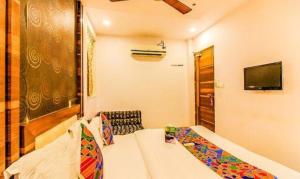 a hotel room with a bed and a television and a room at FabExpress Satellite in Mumbai