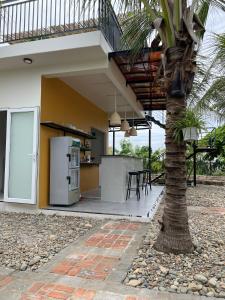 a palm tree in front of a house with a refrigerator at Color Inn - Homestay & Cafe in Ninh Hải