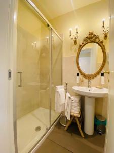 a bathroom with a shower and a sink and a mirror at Palazzo Lari Luxury Accommodation in Sarzana