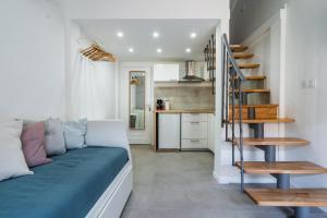 a living room with a couch and a spiral staircase at Bonsai Flat in Beausoleil in Beausoleil