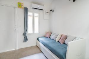 a white room with a blue couch and a window at Bonsai Flat in Beausoleil in Beausoleil