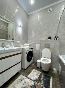 een badkamer met een wasmachine en een toilet bij ЖК Champion с новым ремонтом in Astana