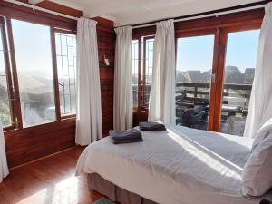 Schlafzimmer mit einem Bett und großen Fenstern in der Unterkunft The beach cabin with pool in Port Alfred