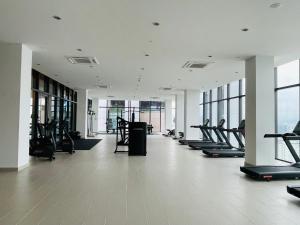 un gimnasio con una fila de cintas de correr y elípticas en KLCC Suites Platinum 2 en Kuala Lumpur