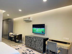 a room with a tv on a wall with a bed at KLCC Suites Platinum 2 in Kuala Lumpur