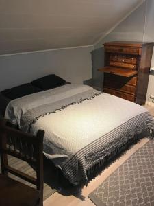 a bedroom with a bed and a wooden dresser at Warm beheiztes gemütliches Haus in der Natur in Sunne