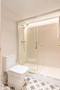 uma casa de banho com uma cabina de duche em vidro e um WC. em Serennia Fira Gran Via Exclusive Rooms em Hospitalet de Llobregat