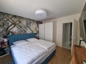 1 dormitorio con 1 cama con cabecero azul en Ferienwohnung am Radweg, en Bad Ems