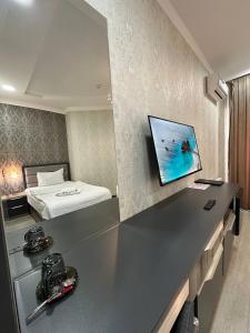 um quarto de hotel com uma cama e uma secretária com um balcão em VIP Hotel em Tashkent