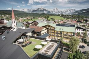 eine Luftansicht einer Stadt mit einer Kirche und Bergen in der Unterkunft Post Seefeld Hotel & SPA in Seefeld in Tirol