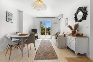 a living room with a table and a couch at Rez de villa avec jardin vue mer in Fréjus +21 photos