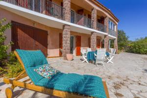 a patio of a house with a deck and chairs at Rez de villa avec jardin vue mer in Fréjus