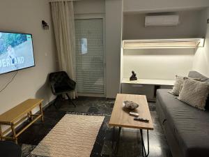 a living room with a couch and a flat screen tv at Central Piraeus 2 in Piraeus