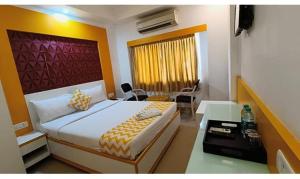 a bedroom with a bed and a desk in a room at FabHotel Prime Stalin Pleasant Park in Chennai