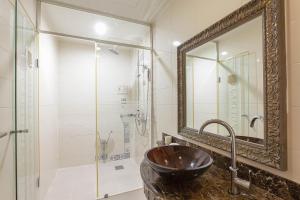 a bathroom with a sink and a shower with a mirror at Carlton Hotel in Paju
