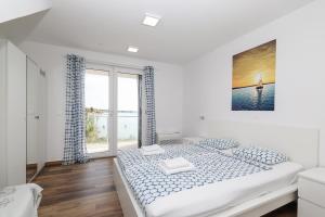 a white bedroom with a large bed and a window at Villa Miri in Privlaka +126 photos