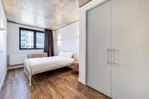 a bedroom with a bed and a sliding door at Botanical-inspired apartments at Repton Gardens right in the heart of Wembley Park in London