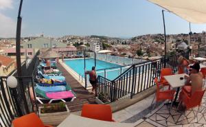 a view of a swimming pool with people sitting in chairs at Surtel Hotel in Kuşadası