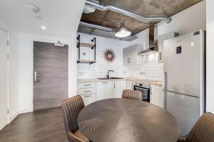 uma cozinha com uma mesa e um frigorífico em Modern and Chic Apartments at Ferrum near Wembley Park em Londres