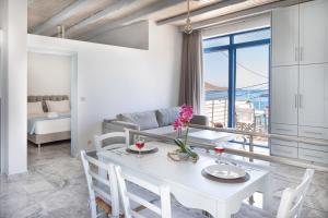 una sala da pranzo bianca con tavolo e sedie bianchi di Plori - Molos Apartments a Loutro