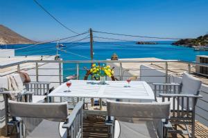 un tavolo e sedie su un balcone con vista sull'oceano di Plori - Molos Apartments a Loutro