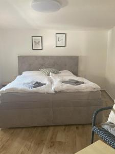 1 dormitorio con 1 cama grande con sábanas blancas en Ubytování u Zuzy, en Velké Pavlovice