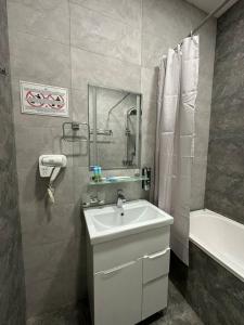 a bathroom with a sink and a shower and a tub at VIP Hotel in Tashkent