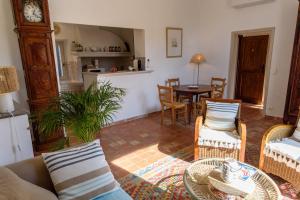 a living room with a table and chairs and a clock at Saint Esprit in Saint-Tropez