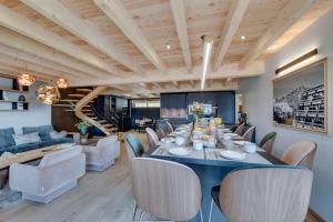 een eetkamer met een lange tafel en stoelen bij Chalet Béla Vya 5 étoiles luxe Ski & Spa in Bourg-Saint-Maurice