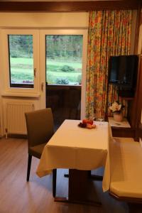 jadalnia ze stołem i krzesłem oraz 2 oknami w obiekcie Ferienhaus Brigitte w Langenfeld
