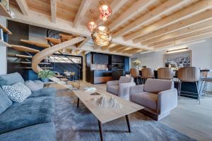 een woonkamer met een bank en een tafel bij Chalet Béla Vya 5 étoiles luxe Ski & Spa in Bourg-Saint-Maurice